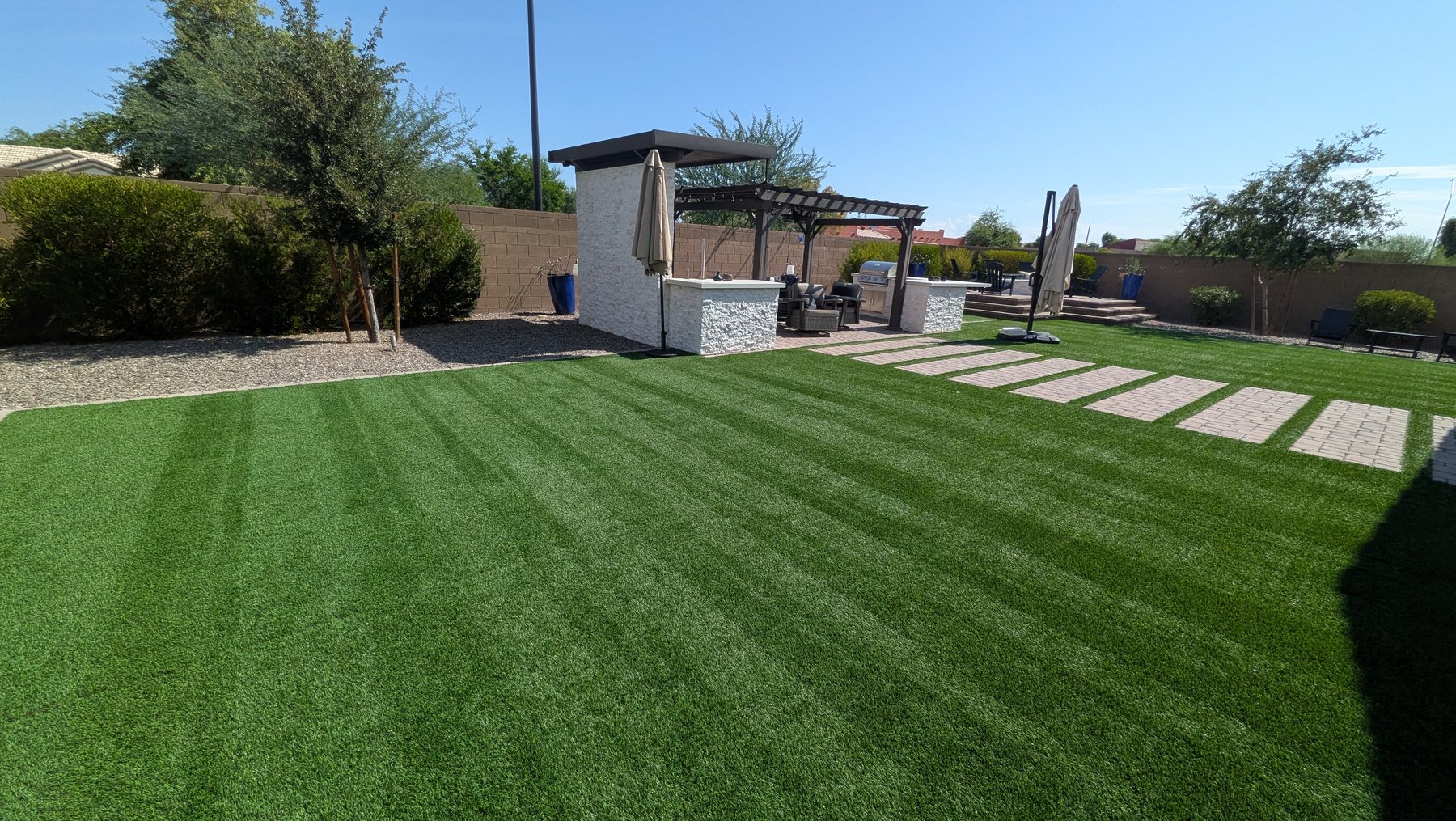 Freshly cleaned and power-brushed artificial turf with crisp groom lines in a Phoenix-area backyard